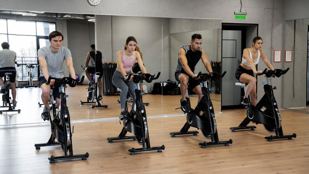 Usuarios de un gimnasio realizan una sesión de spinning.