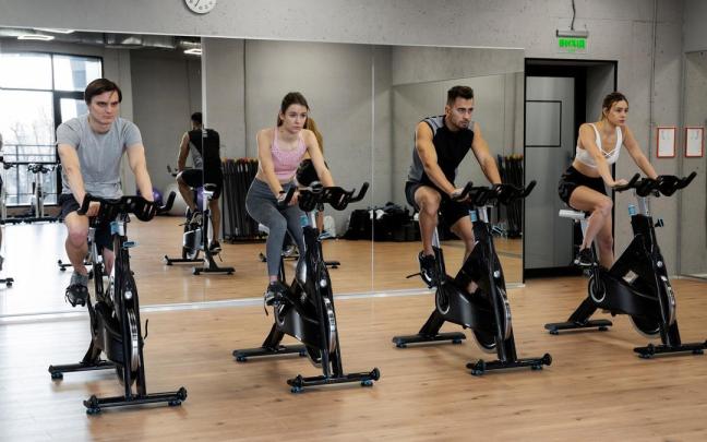 Usuarios de un gimnasio realizan una sesión de spinning.