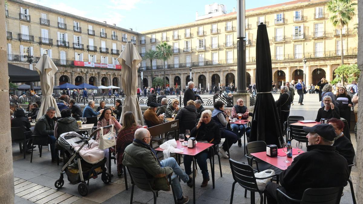 Gente sentada en las terrazas de la Plaza Nueva en Bilbao.