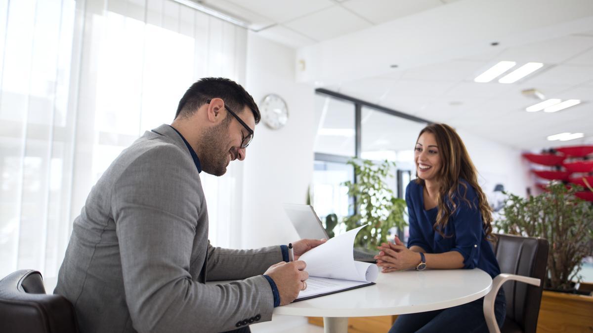 Un reclutador de personal entrevista a una mujer para cubrir una vacante.