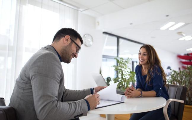 Un reclutador de personal entrevista a una mujer para cubrir una vacante.