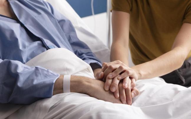 Un familiar acompaña a un paciente en el hospital.