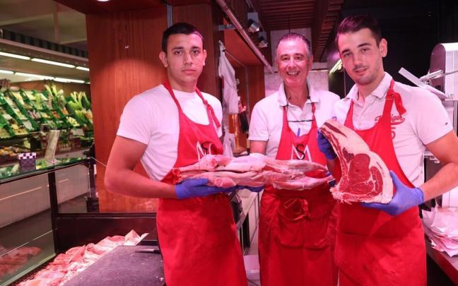 Juan Andrés San Miguel, con sus hijos, Pablo y Andrés, en su carnicería del Mercado del Ensanche