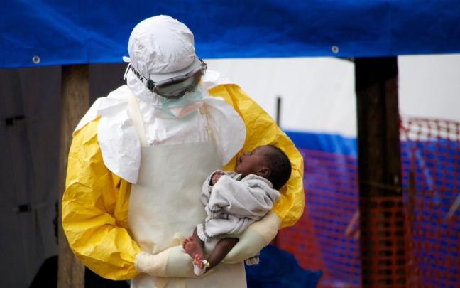 Un doctor sostiene un bebé de dos meses, posiblemente infectado con el virus del ébola.