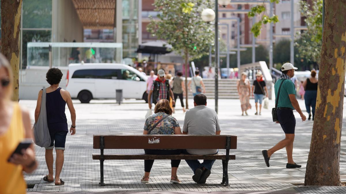 Dos personas descansan en un banco de Vitoria-Gasteiz.