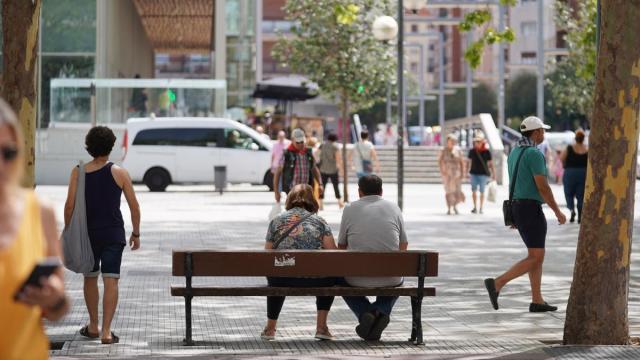 Dos personas descansan en un banco de Vitoria-Gasteiz.