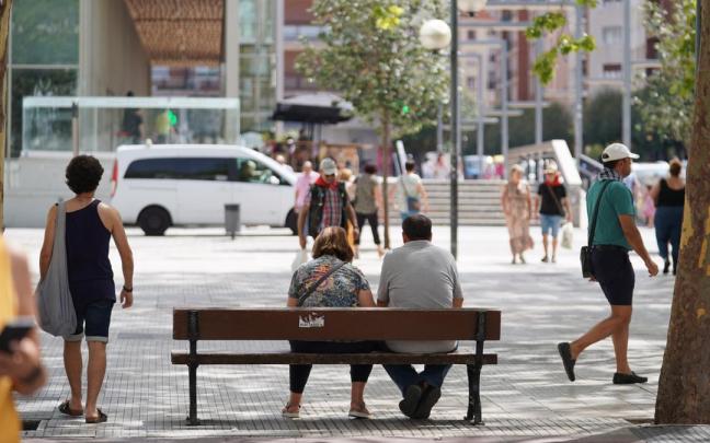 Dos personas descansan en un banco de Vitoria-Gasteiz.