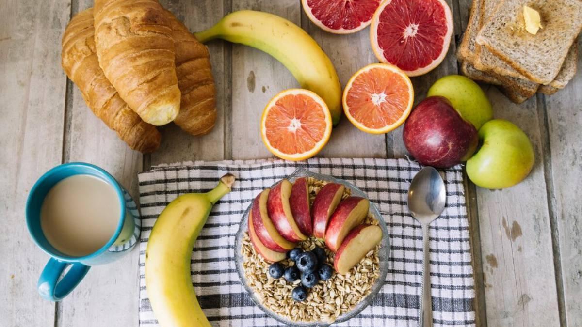 Desayuno con avena, tostadas, croissants y fruta.