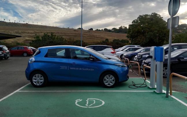 Un coche eléctrico carga su batería en una electrolinera. Un coche eléctrico carga su batería en una electrolinera.