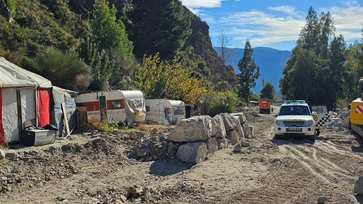 Trabajos en el cauce de río Sucio en Órgiva, con caravanas al fondo.
