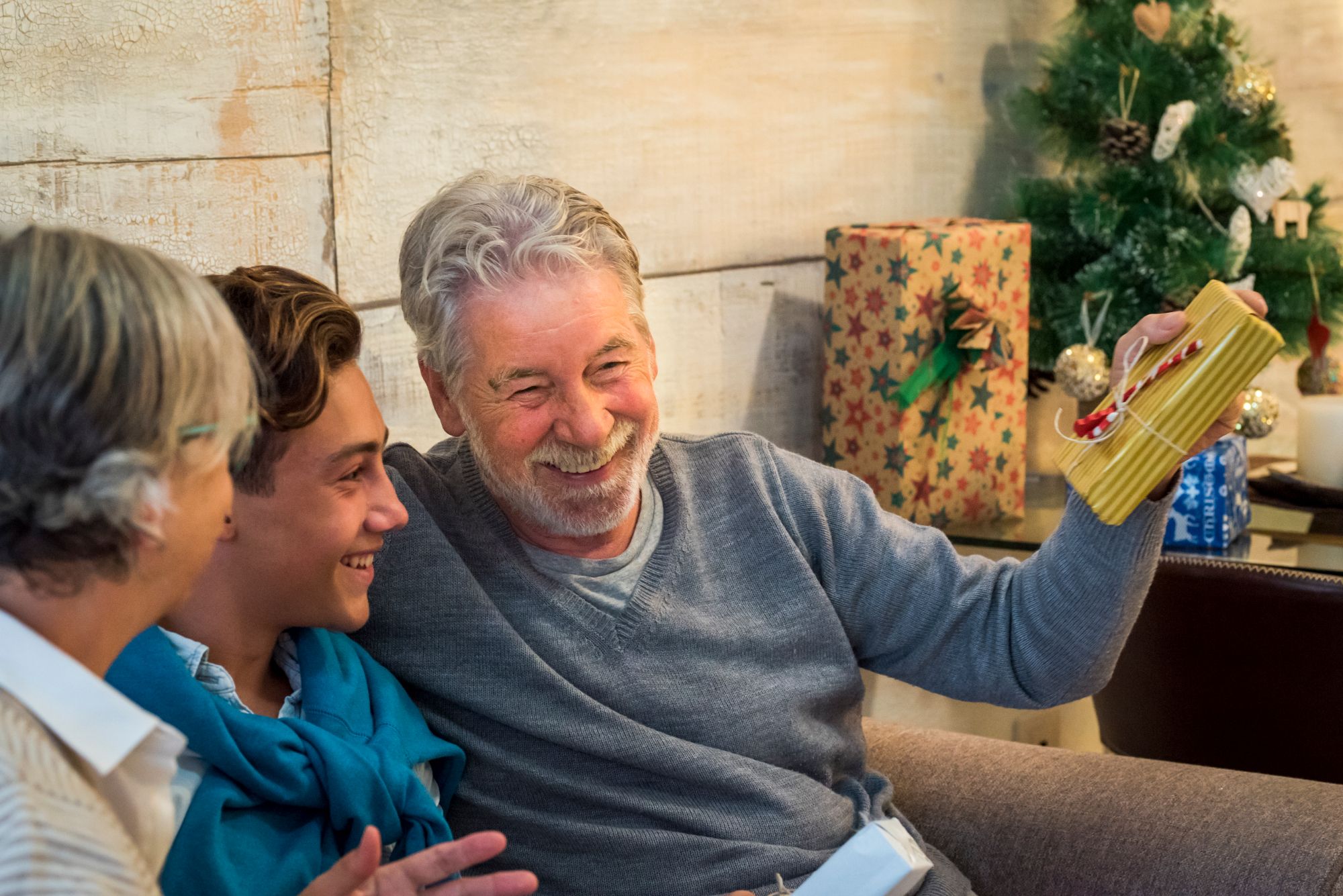 Abuelos y nieto intercambian regalos durante la Navidad.