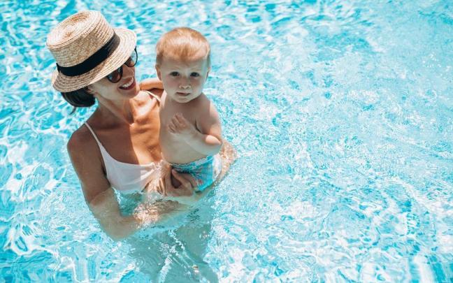 Madre e hijo se dan un baño en la piscina.
