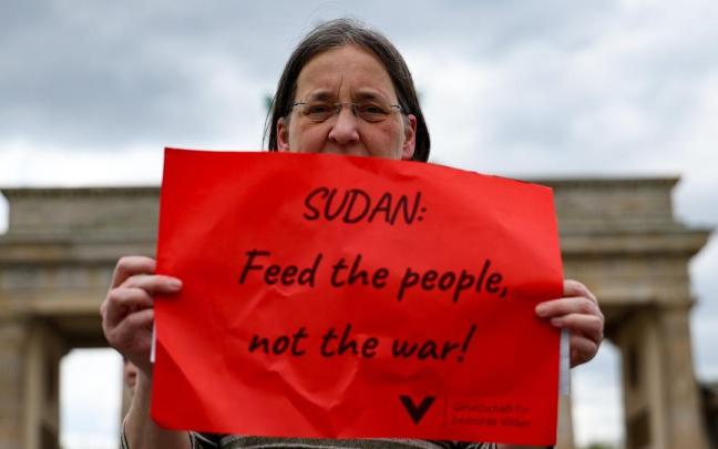 Una mujer sostiene un cartel en Alemania en el que pide alimentar a la gente en Sudán, no la guerra. / EFE Una mujer sostiene un cartel en Alemania en el que pide alimentar a la gente en Sudán, no la guerra.
