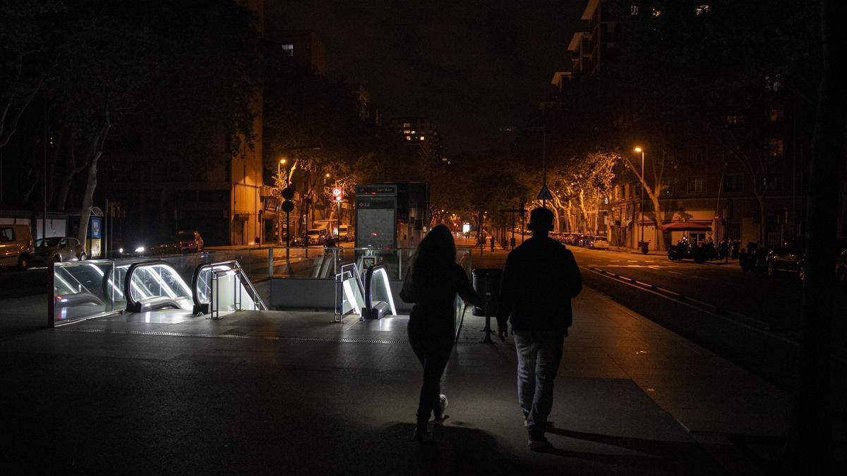 Dos personas pasean por una calle apenas iluminada durante el apagón.