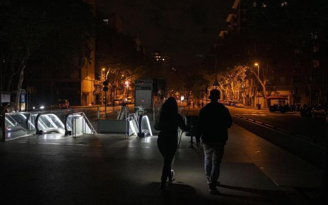 Dos personas pasean por una calle apenas iluminada durante el apagón.