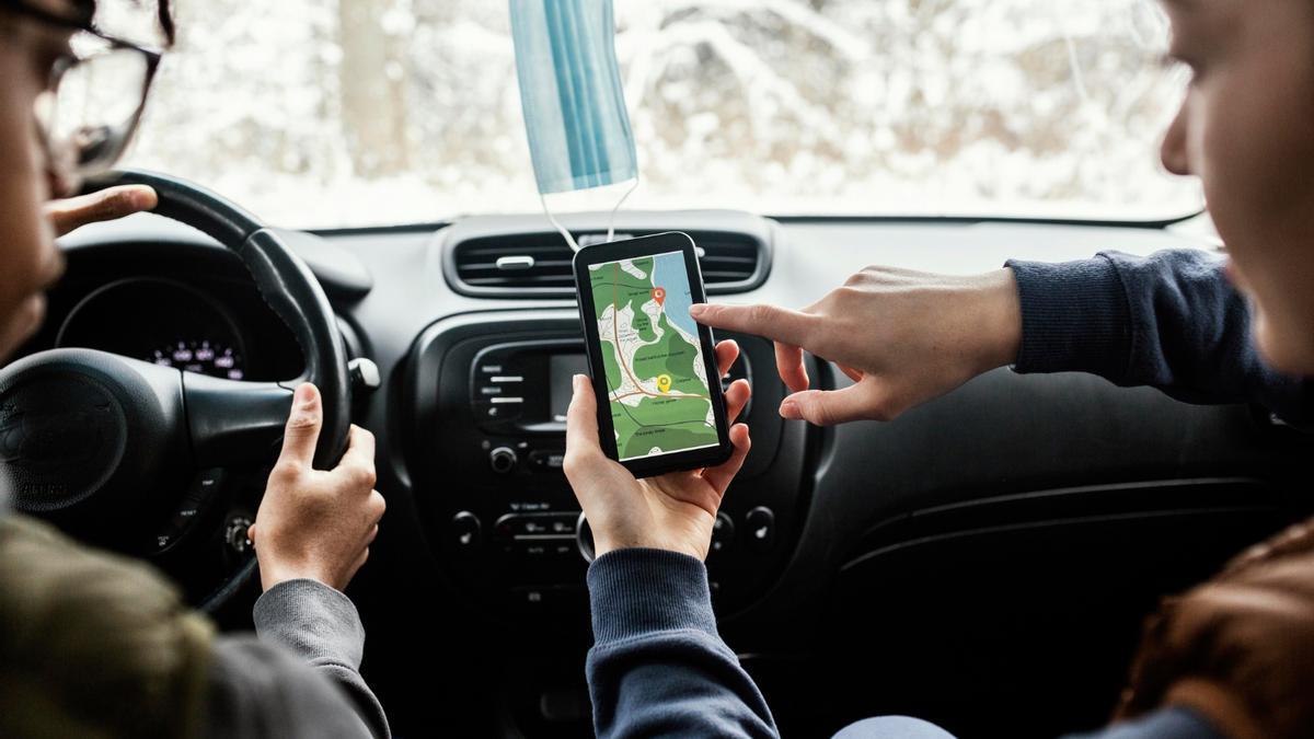Dos jóvenes usan el navegador dentro del coche.