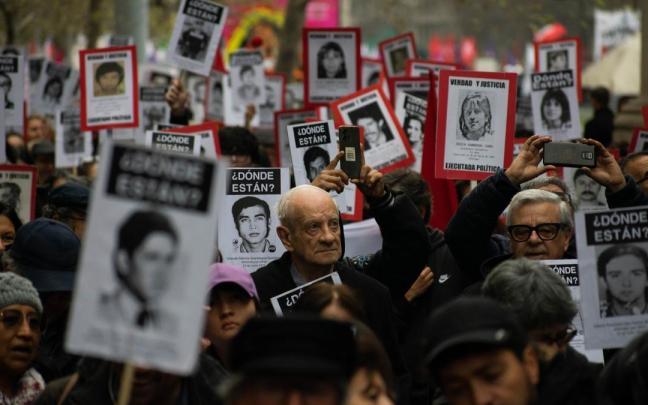 Miles de chilenos marchan con imágenes de desaparecidos y asesinados durante la dictadura. Miles de chilenos marchan con imágenes de desaparecidos y asesinados durante la dictadura.