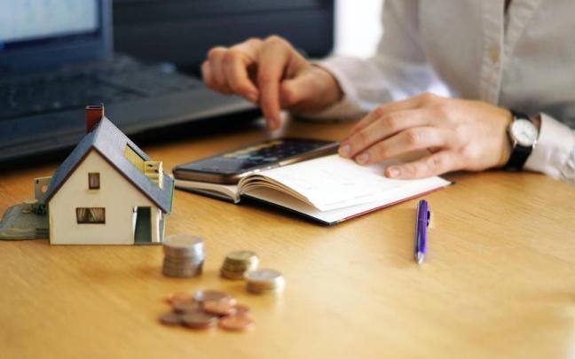 Una persona realiza cálculos para afrontar la compra de una vivienda