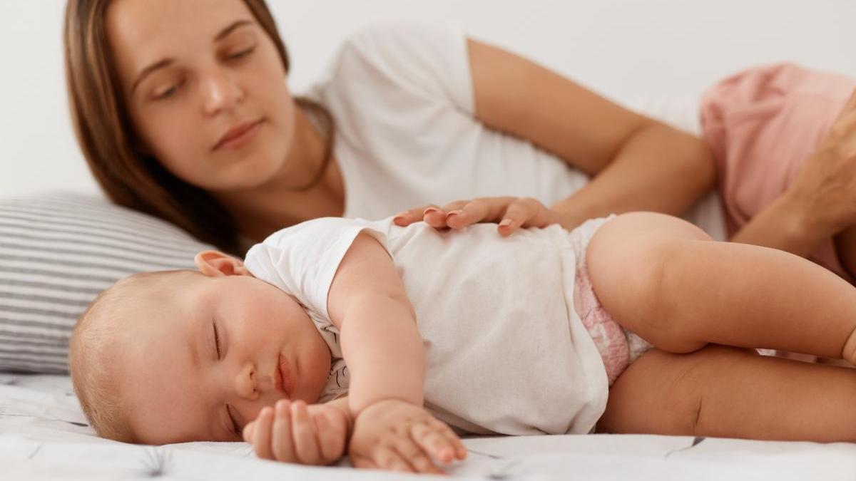 Madre durmiendo a su bebé.