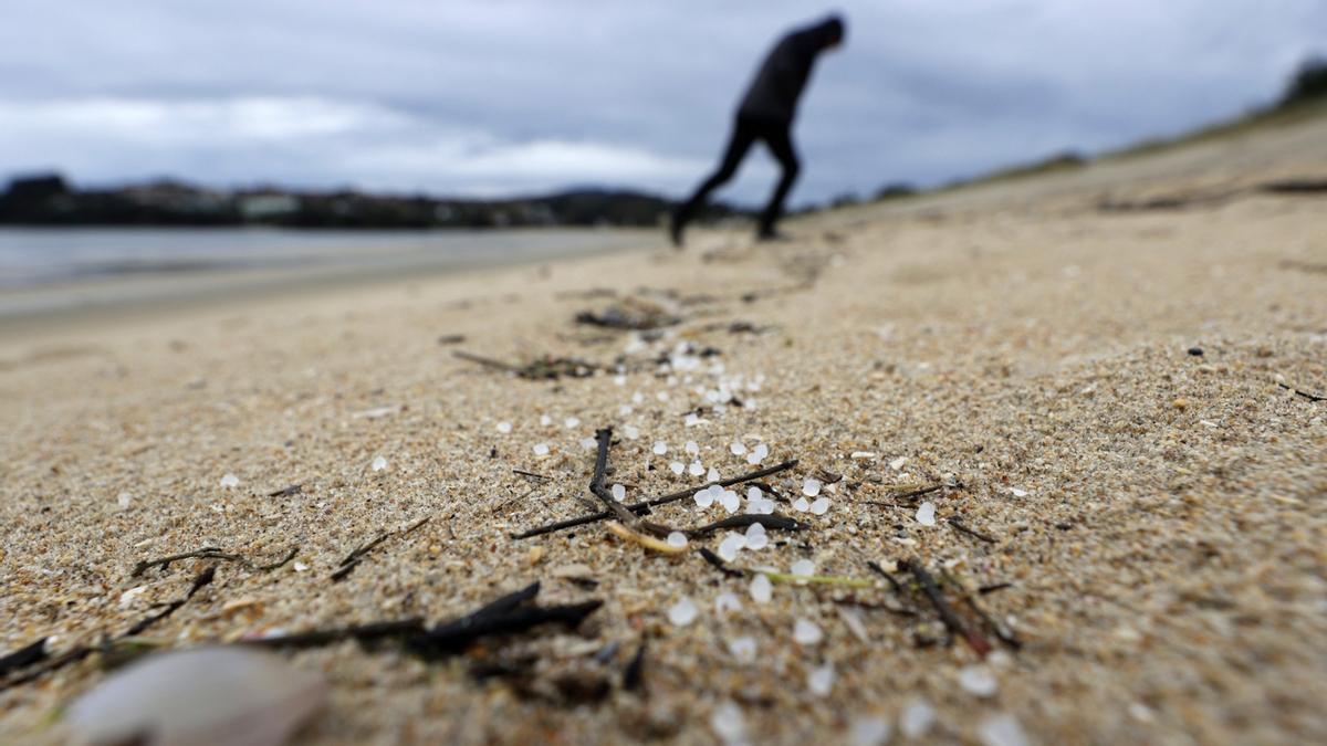 Una persona camina por la playa Grande de Miño, en una jornada en la que siguieron llegando a los arenales gallegos de pellets de plástico.