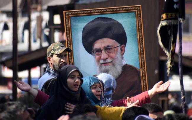 Iraníes muestran el retrato del exlíder supremo, Ali Jamenei.