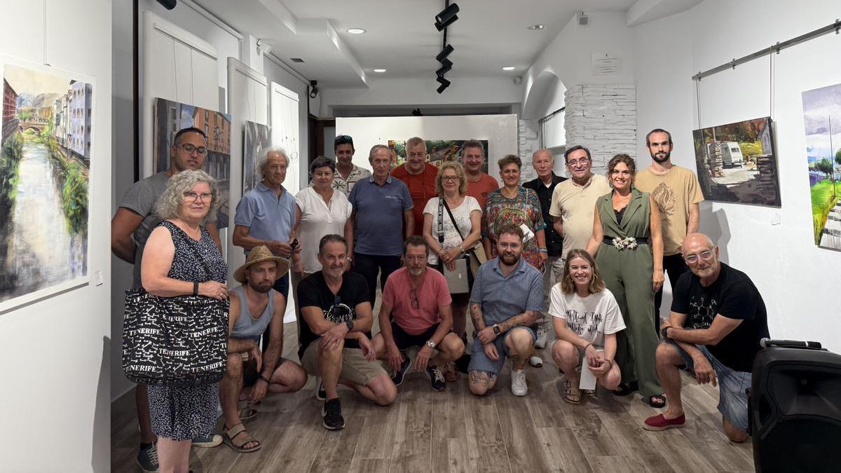 Pintores participantes en el concurso y los miembros del jurado posan junto a las obras presentadas.