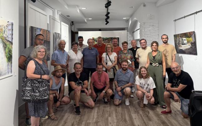 Pintores participantes en el concurso y los miembros del jurado posan junto a las obras presentadas.