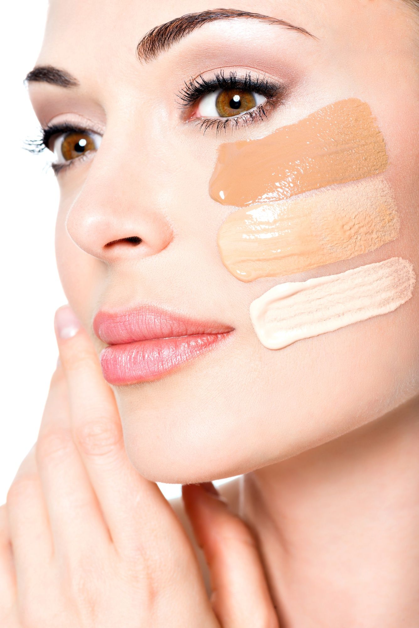 Tres tonos de base de maquillaje sobre la piel del rostro.