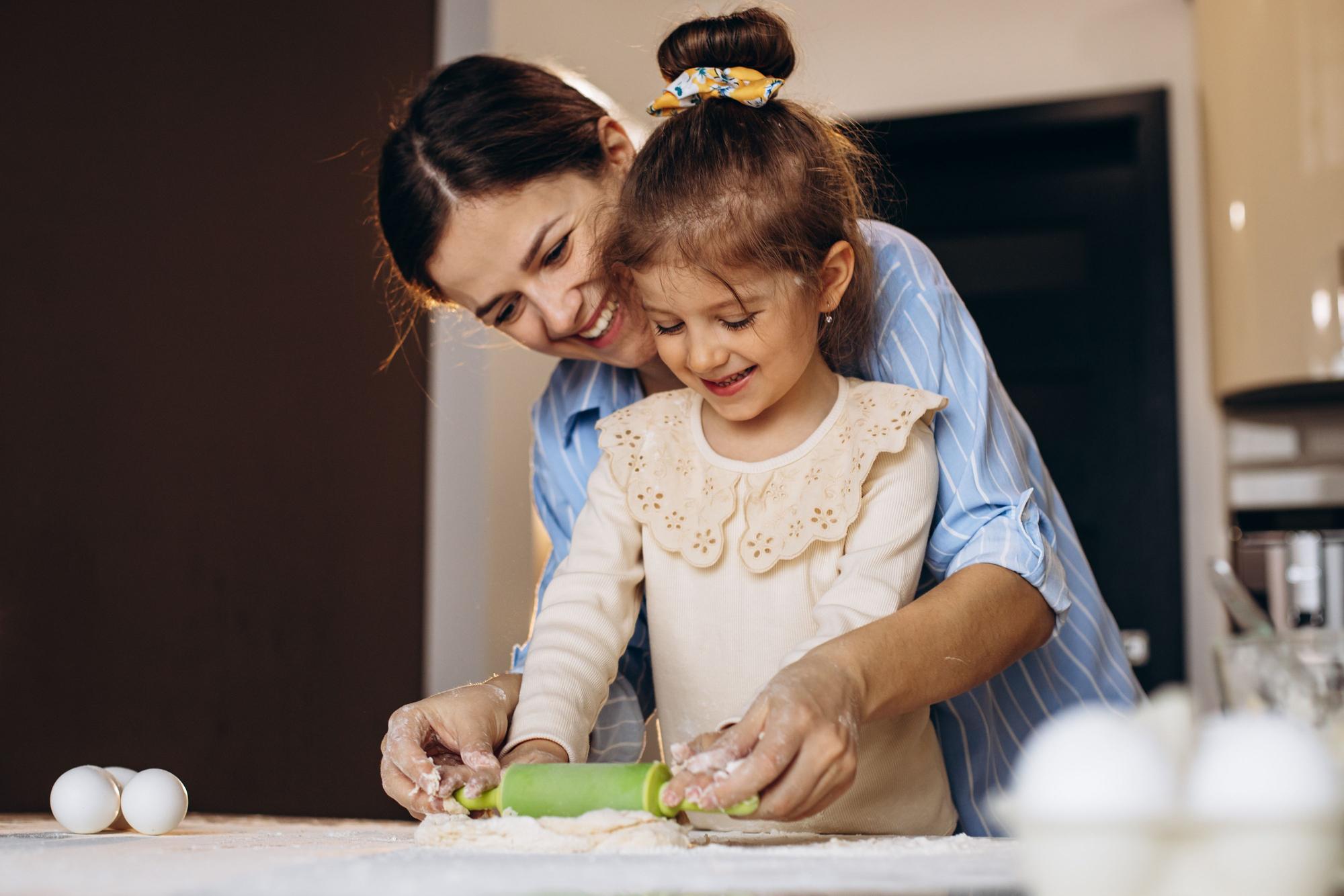 Niña cocina con su madre.