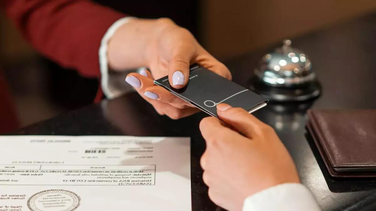 Un cliente entrega información personal en la recepción de un hotel