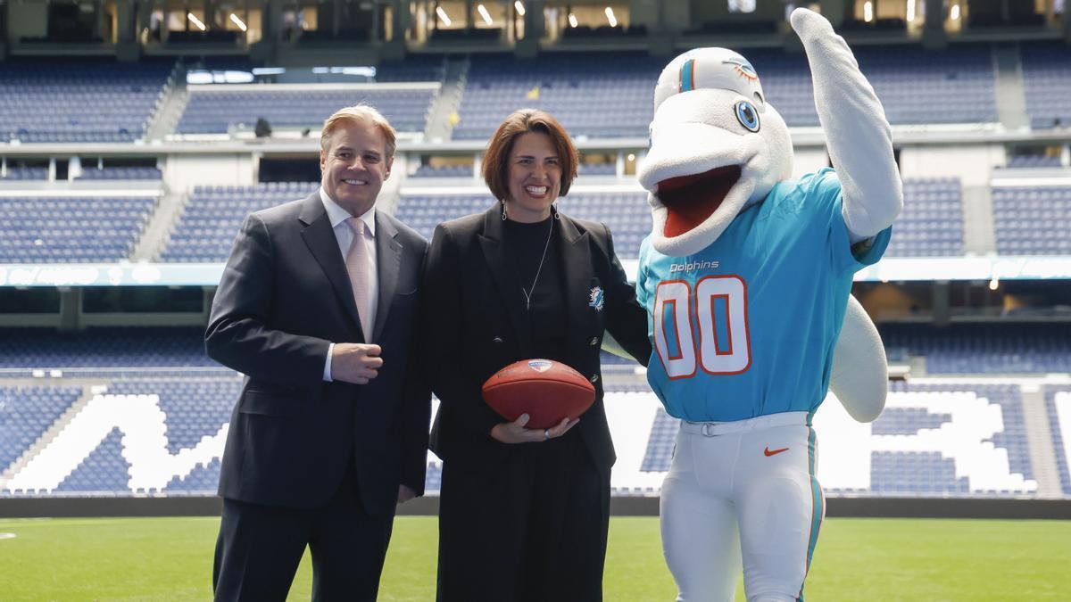 Brett Gosper, director de la NFL en Europa y Asia-Pacífico y Pri Shumate, vicepresidenta de los Miami Dolphins, en el césped del estadio Santiago Bernabéu con la mascota del equipo