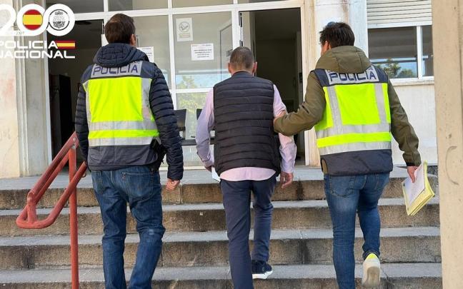 Los agentes acompañan al detenido por supuesta estafa inmobiliaria.