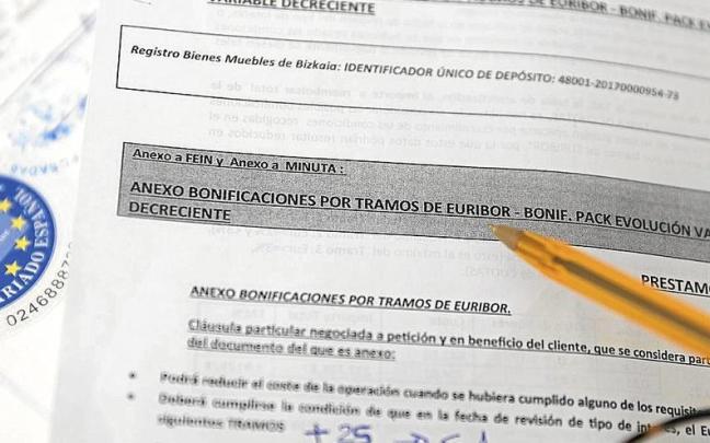 Una persona examina la documentación para la firma de una hipoteca. Una persona examina la documentación para la firma de una hipoteca.