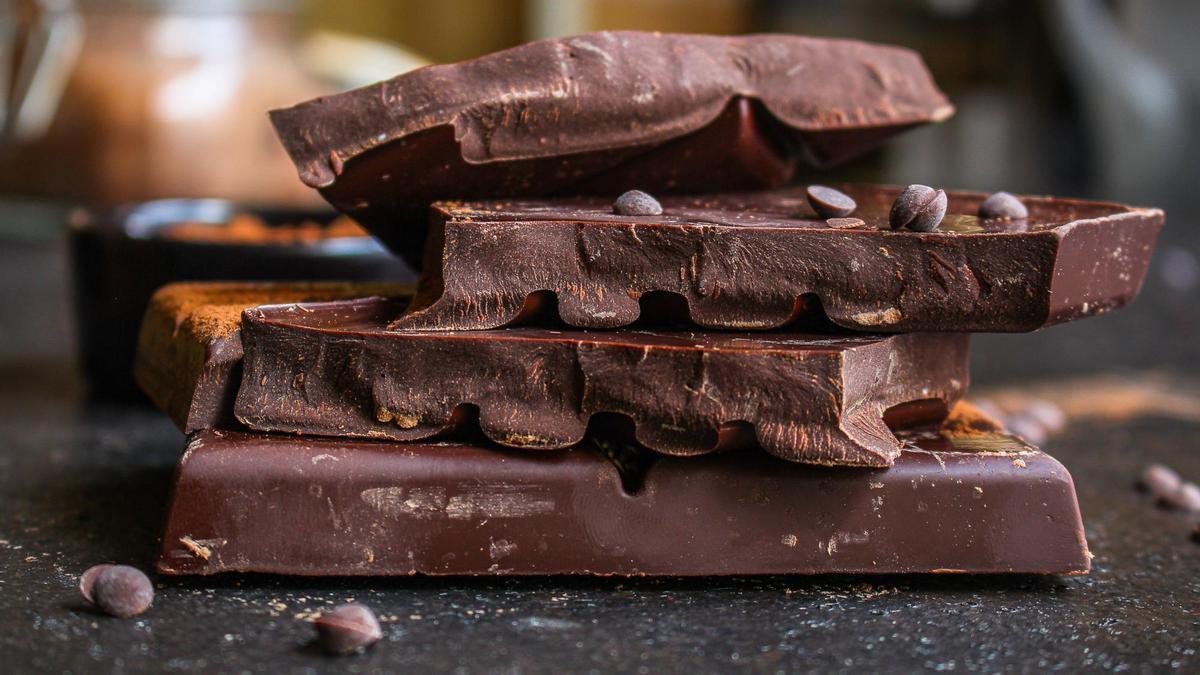 Trozos de tabletas de chocolate apilados y con pepitas salteadas.