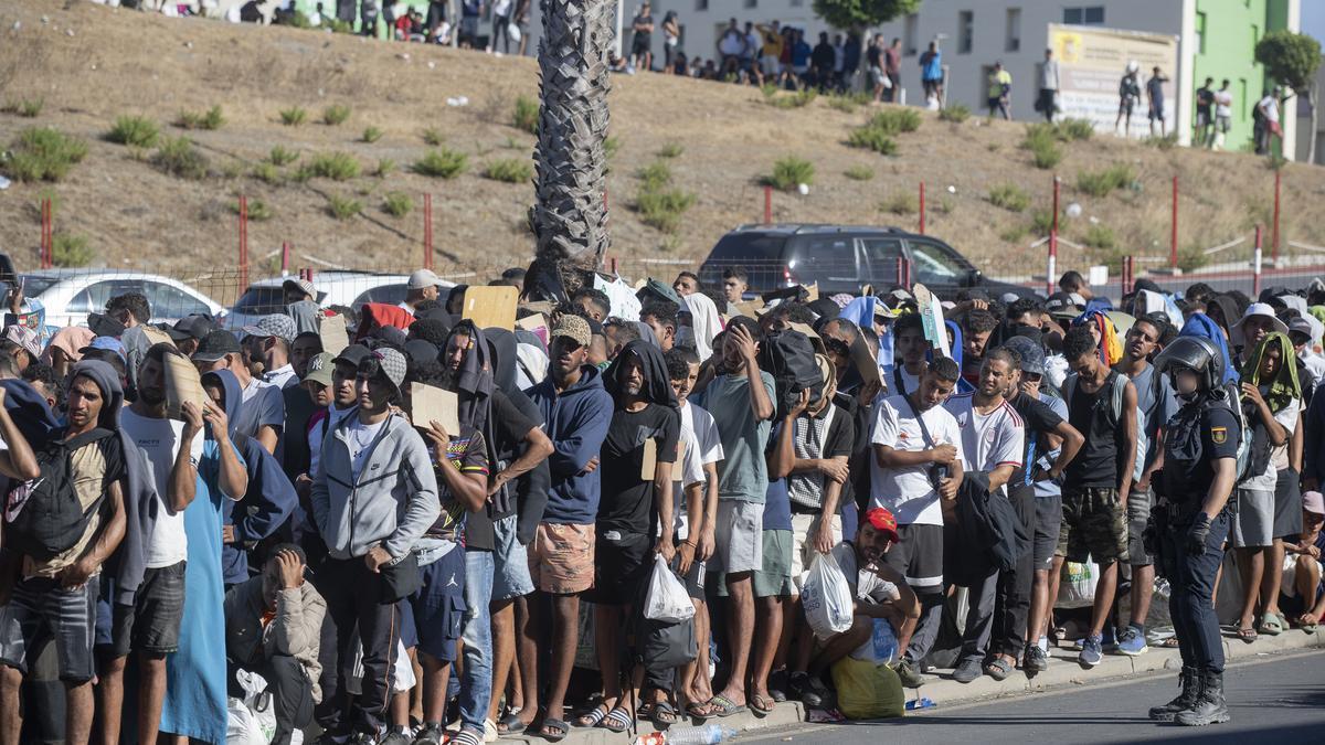 Migrantes esperan en una cola en Ceuta.
