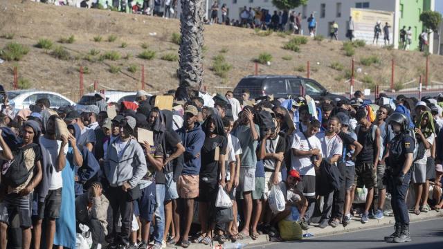 Migrantes esperan en una cola en Ceuta.