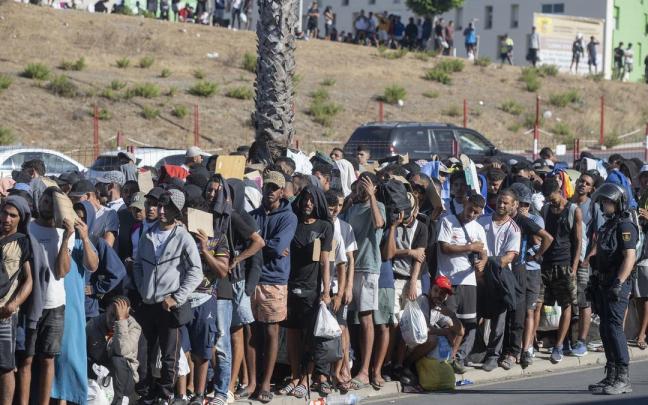 Migrantes esperan en una cola en Ceuta.