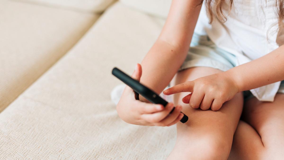 Una niña utiliza un teléfono móvil inteligente.