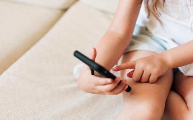 Una niña utiliza un teléfono móvil inteligente.