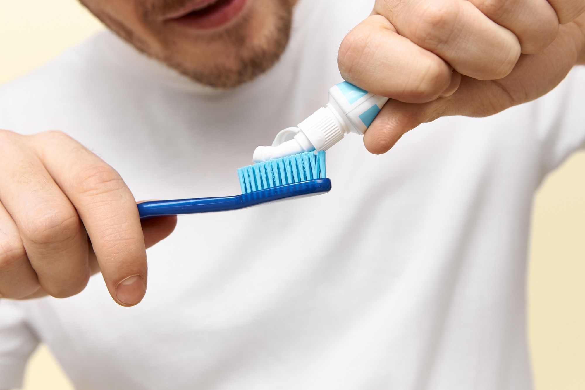 Un hombre coloca el dentífrico en el cepillo de dientes.