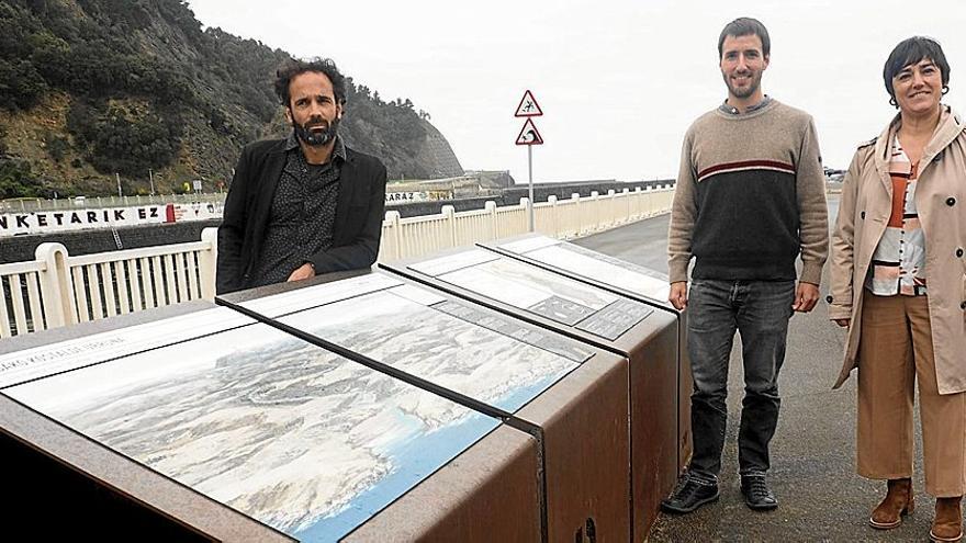 Asier Hilario, Gilen García y Leire Barriuso, junto a los paneles instalados a la altura de la desembocadura del río Deba y la playa.