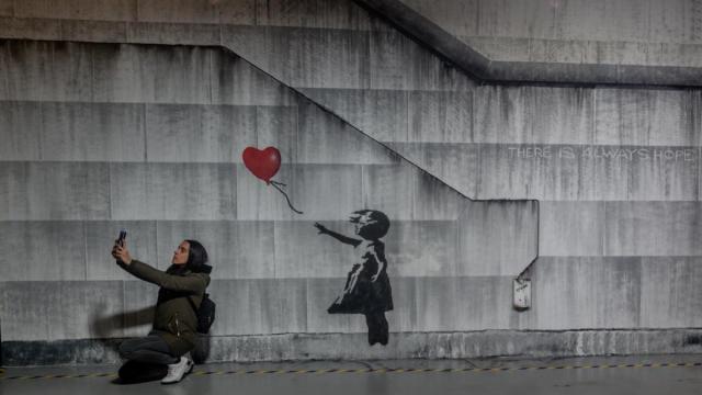 Varias personas recorren la exposición permanente de las obras de Banksy, en el Museo Banksy de Madrid.