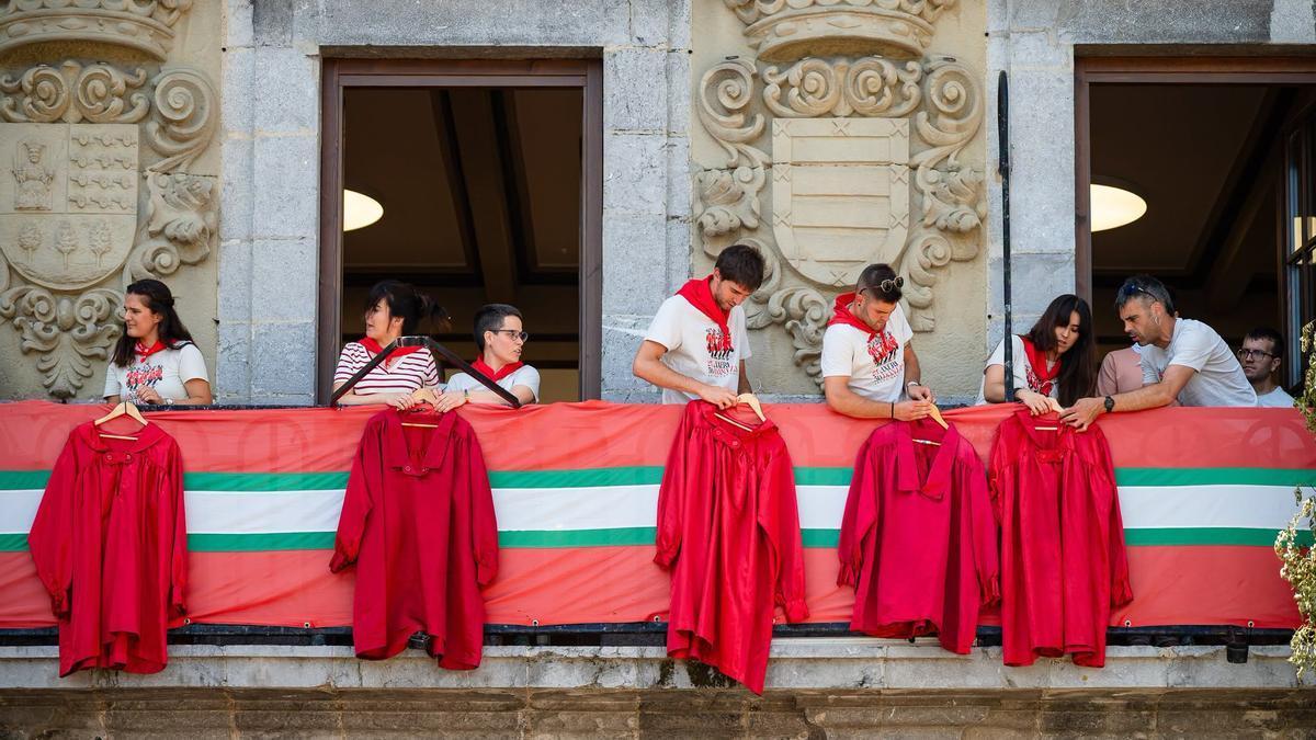 Integrantes de Axeri dantza colocan sus casacas en el ayuntamiento.