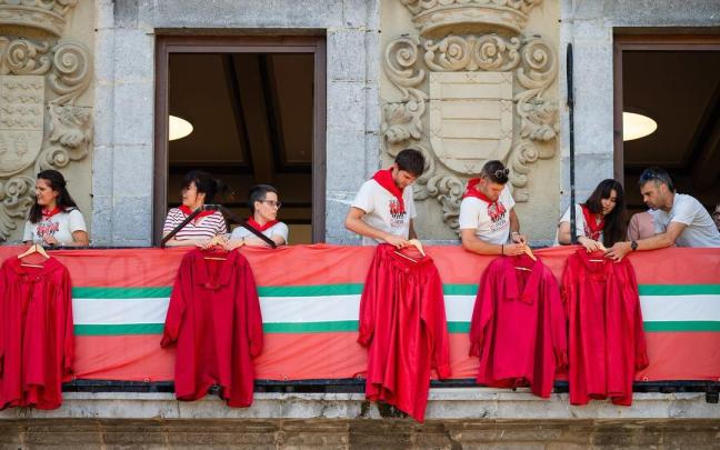 Integrantes de Axeri dantza colocan sus casacas en el ayuntamiento.
