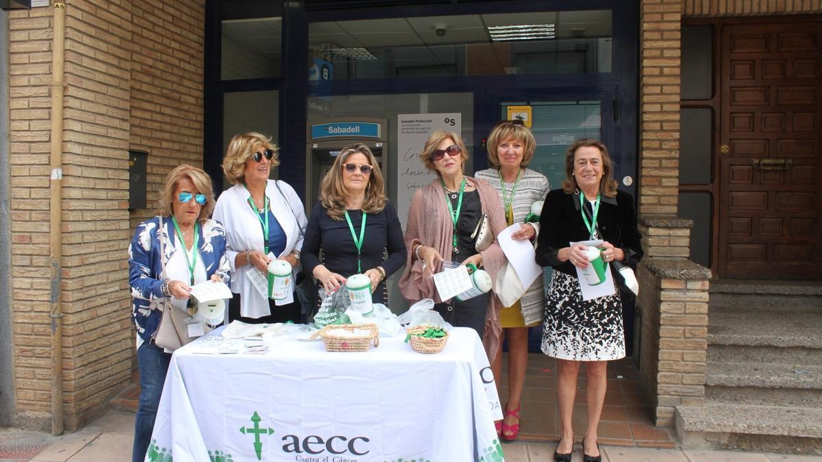 Un grupo de mujeres colabora en la recogida de donativos para la lucha contra él cáncer.