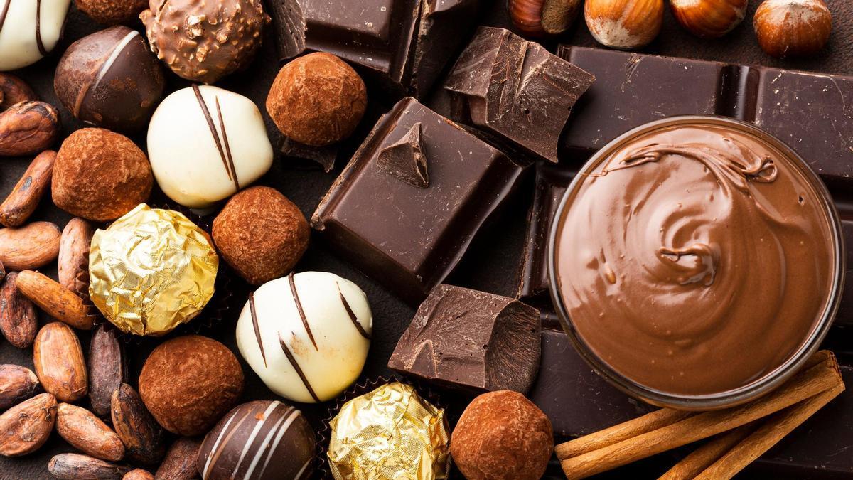 Distintas variedades de chocolate junto a unos granos de cacao.
