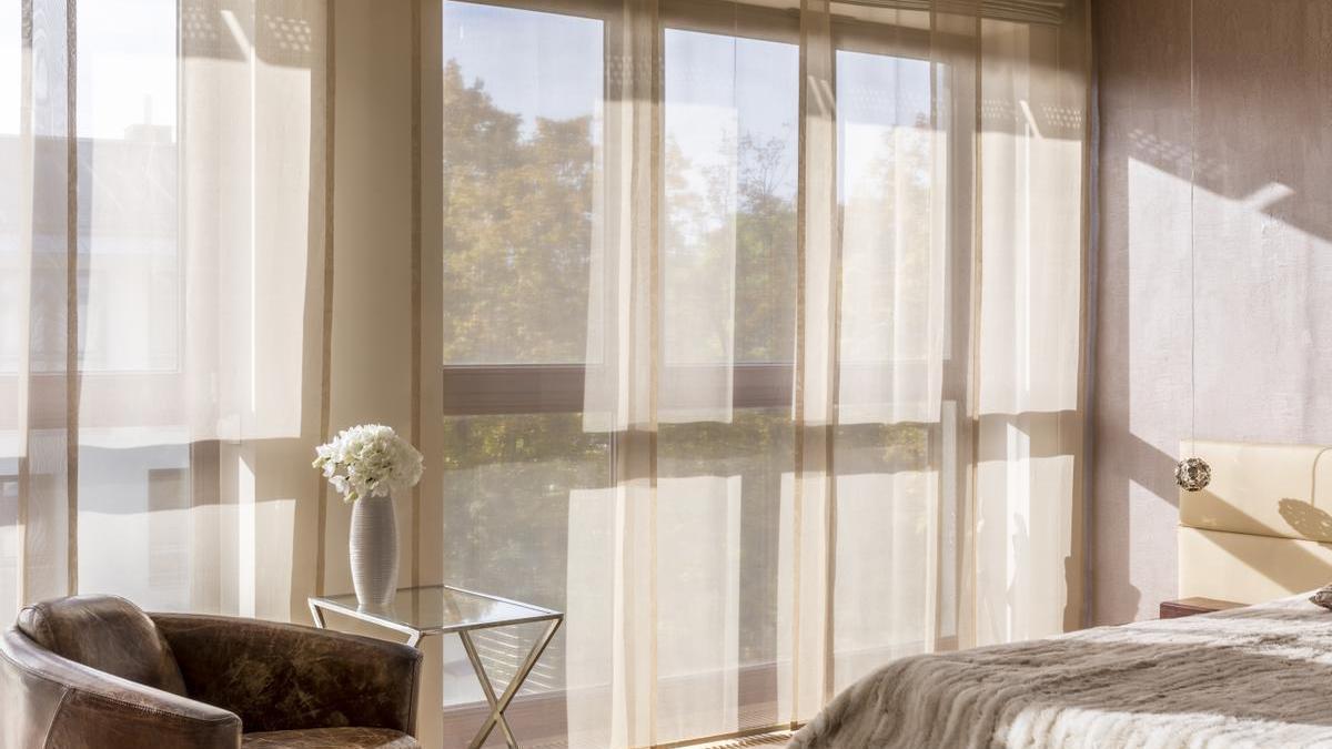 Dormitorio con cortinas hasta el suelo.