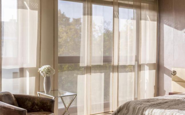 Dormitorio con cortinas hasta el suelo.