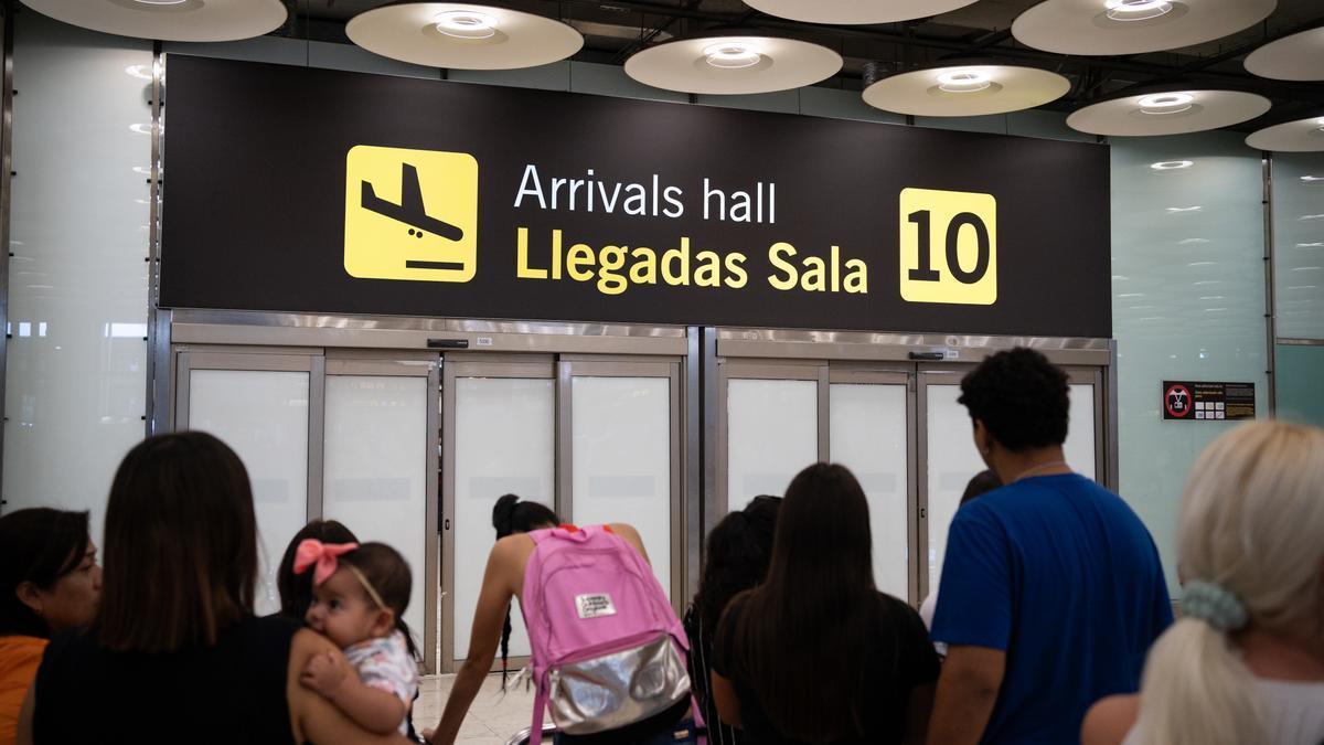 Varias personas esperan la llegada de pasajeros en la T4 del Aeropuerto Adolfo Suárez Madrid-Barajas.