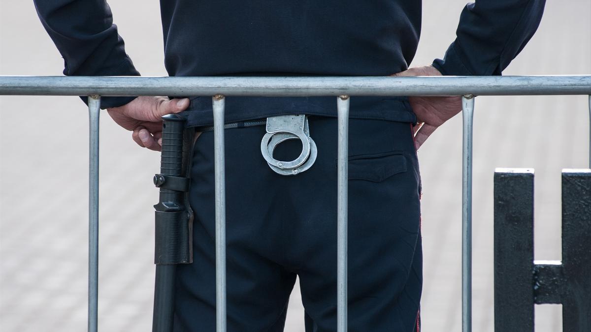 Un policía ruso con un par de esposas y una porra.